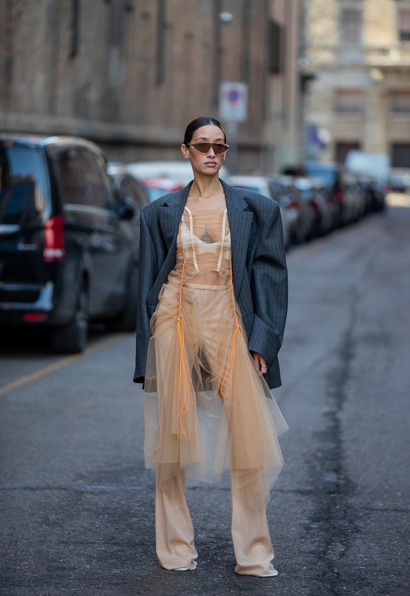 MILAN, ITALY - FEBRUARY 25: Alexandra Guerain seen wearing grey striped blazer, sunglasses, beige sh...