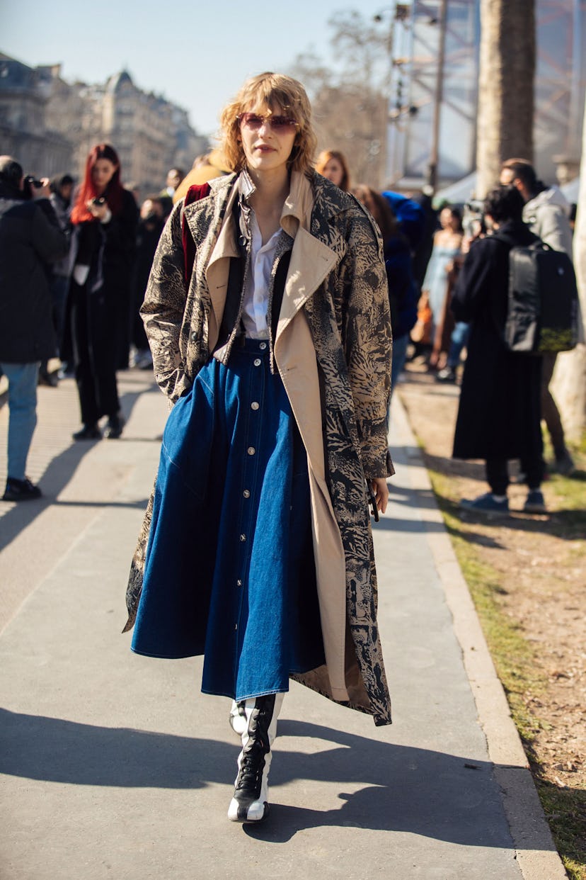 PARIS, FRANCE - MARCH 08: Model Aivita Muze wears an animal print tan trench coat, white top, denim ...