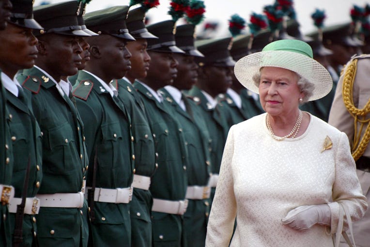 Britain's Queen Elizabeth II reviews the honor guard upon her arrival at Nnamdi Azikiwe Internationa...