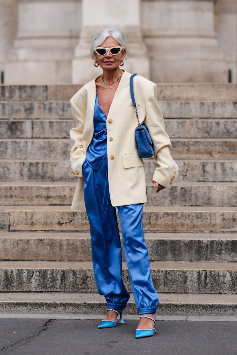 PARIS, FRANCE - MARCH 01: A guest wears a beige vintage sunglasses, gold with embroidered rhinestone...