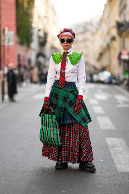 PARIS, FRANCE - MARCH 05: A guest wears a red / dark green / yellow checkered print pattern beret wi...