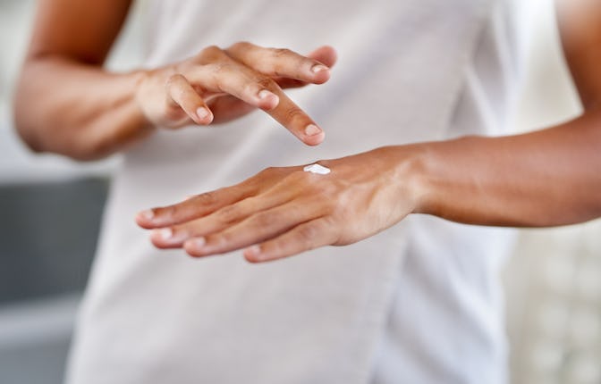 Cropped shot of a woman applying moisturiser to her hands during her morning beauty routine