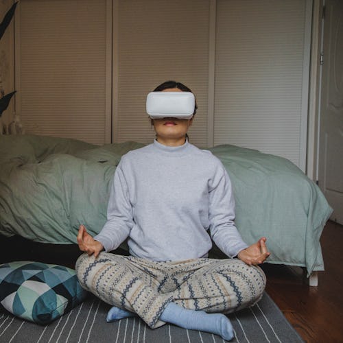 A woman wearing the Oculus Quest 2 meditates in virtual reality. Here's how a virtual reality mediat...