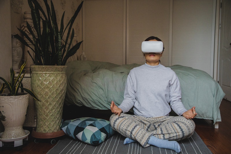 A woman wearing the Oculus Quest 2 meditates in virtual reality. Here's how a virtual reality mediat...
