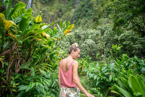 Young woman walking inside rainforest, Maui, Hawaii. People travel sharing nature concept