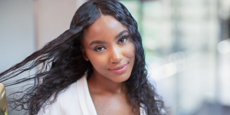 Portrait confident beautiful young woman brushing long black hair