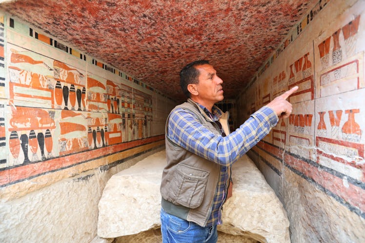 An archaeologist introduces the mural painting in an ancient tomb uncovered at Saqqara archaeologica...