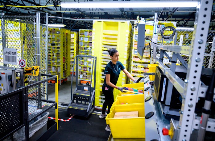 A woman works at a distrubiton station at the 855,000-square-foot Amazon fulfillment center in State...