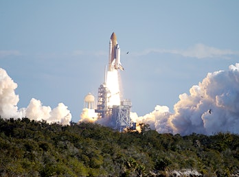 Through a cloud-washed blue sky above Launch Pad 39A, Space Shuttle Columbia hurtles toward space on...