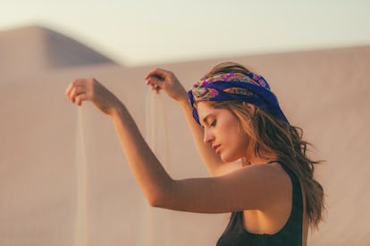 May 2, 2022 Weekly Horoscope For Every Zodiac Sign Amid Taurus Season 3 Young woman sifting sand through her hands, embracing the May 2, 2022 weekly horoscope for her zodia...