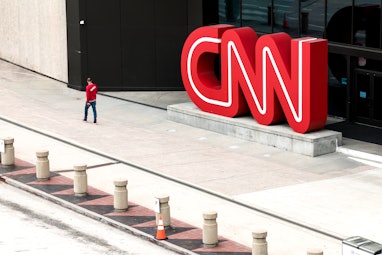 ATLANTA, GEORGIA - MARCH 15: People walk by the world headquarters for CNN on March 15, 2022 in Atla...