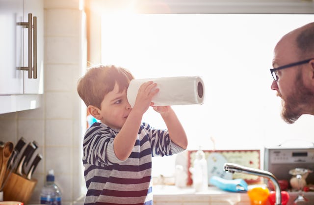 Little boy doing chores in the kitchen with his dad