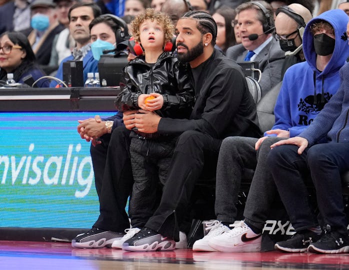TORONTO, ON - APRIL 7: Drake sits with his son Adonis while the Toronto Raptors play the Philadelphi...