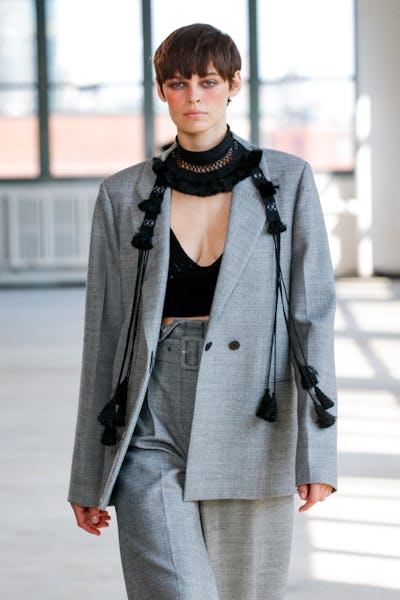 A model wearing a grey suit an dblack crochet top on the Altuzarra Spring/Summer runway
