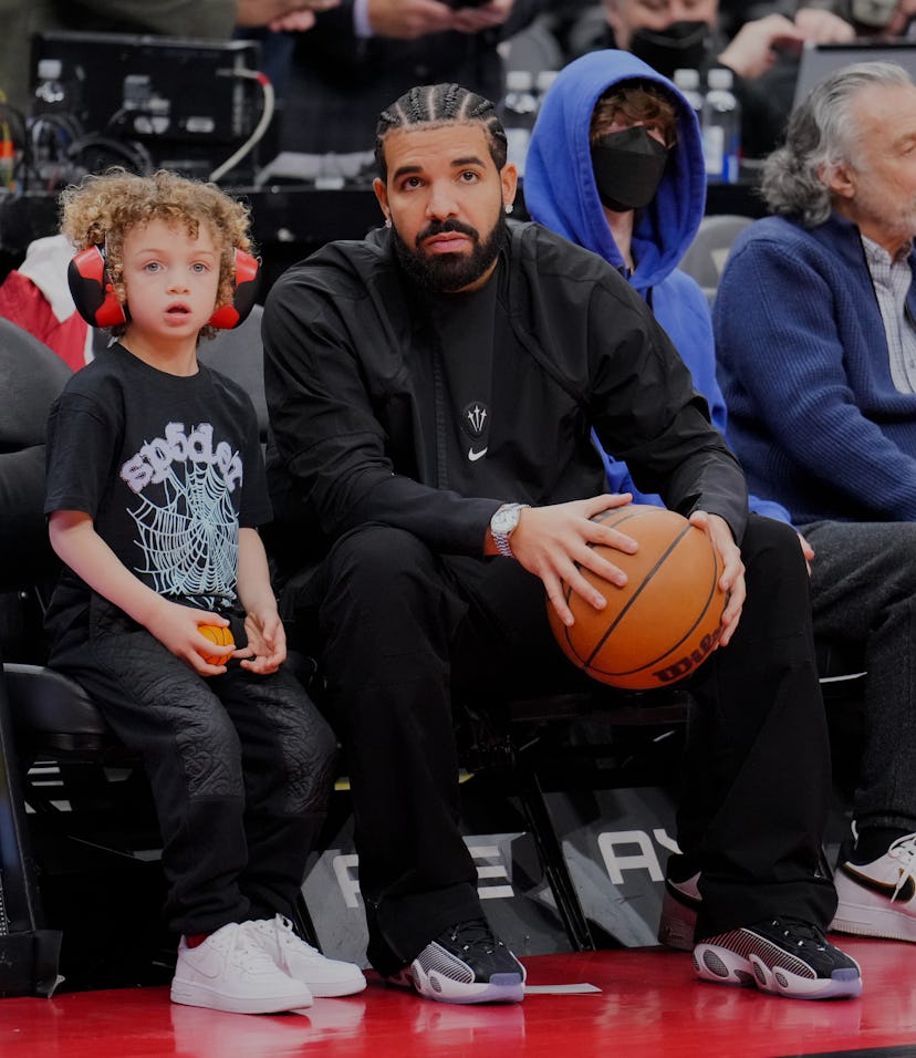 TORONTO, ON - APRIL 7: Drake sits with his son Adonis before the Toronto Raptors play the Philadelph...