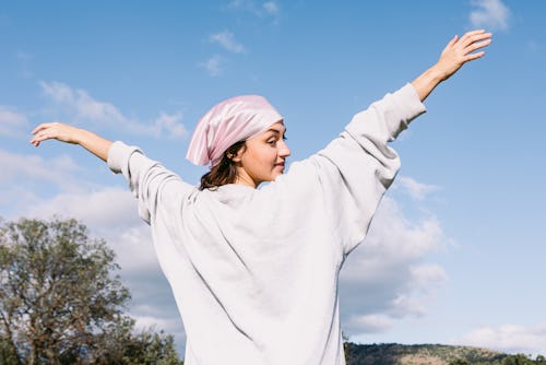 Young girl in the field with her back turned with a pink scarf on her head. Here's your daily horosc...