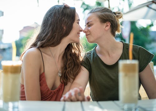 Queer couple looking at each other while holding hands. Is taurus compatible with gemini in relation...