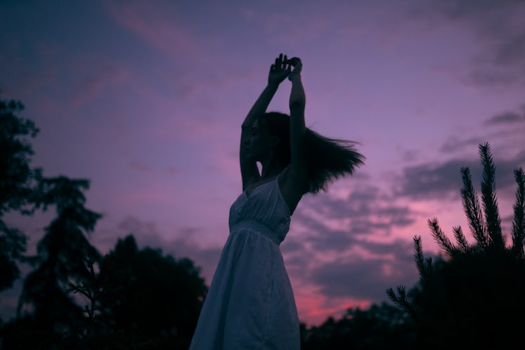 Young woman dancing during the twilight hours, knowing her unlucky zodiac sign will have the worst m...