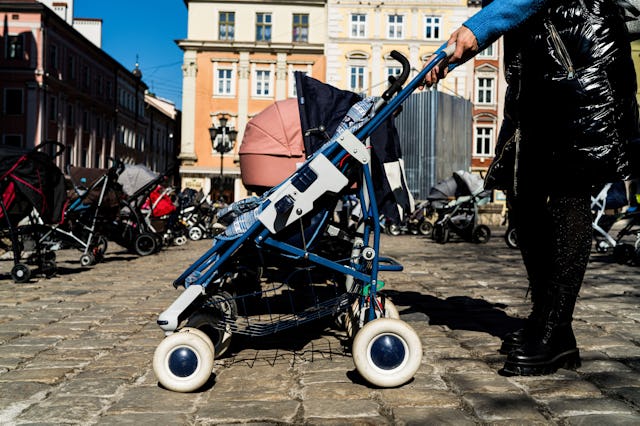 A woman seen with a stroller in Rynok Square during a memorial. Many parents in Ukraine have fled th...