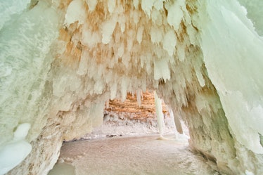 Image of Ice cavern covered in small icicles and frozen lake on the ground