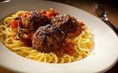Close up spaghetti and meatballs on a white plate with Italian herb & tomato sauce, Newport, Wales, ...