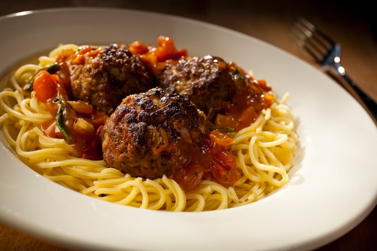 Close up spaghetti and meatballs on a white plate with Italian herb & tomato sauce, Newport, Wales, ...