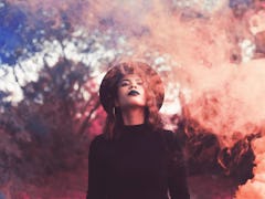 Young woman surrounded by smoke, feeling empowered by the fact that Friday the 13th 2022 will be the...