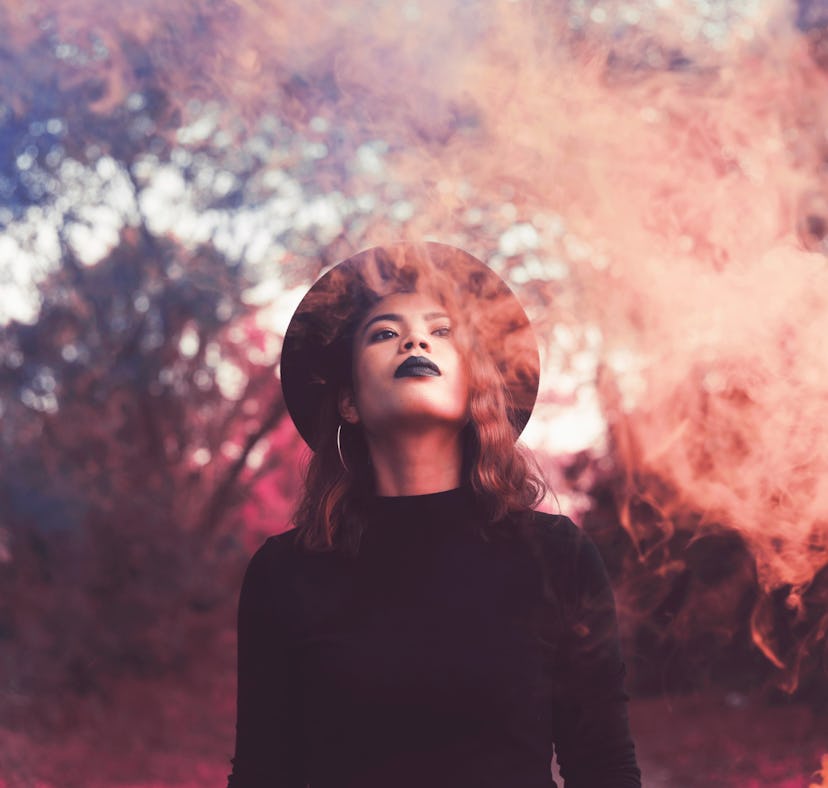 Young woman surrounded by smoke, feeling empowered by the fact that Friday the 13th 2022 will be the...