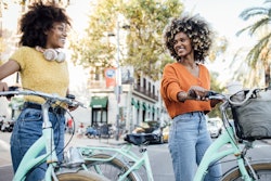 Two women bike through a city. Here's your daily horoscope for today, April 15, 2022.