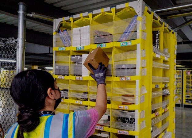 EASTVALE, CA - AUGUST 31: Worker Melissa Navarrete Urena stows goods into a movable pallet at Amazon...