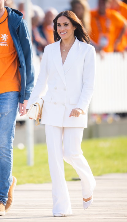 Meghan Markle wears a white Valentino Spring/Summer 2022 pantsuit.
