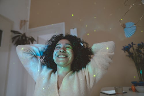 A woman with a star projector in her room. How to read your horoscope correctly, according to an ast...