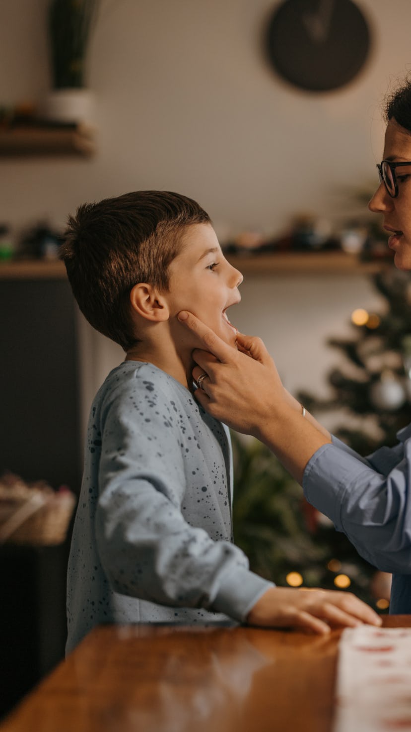 Mother sitting and looking son's mouth and teeth