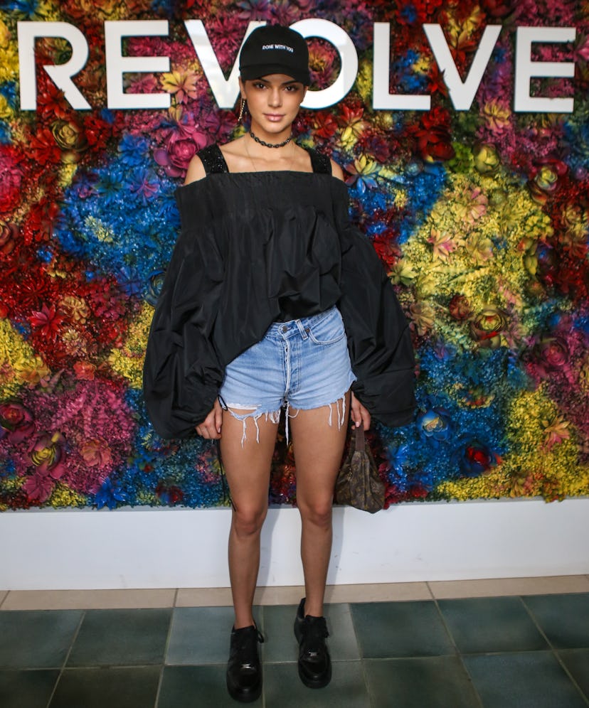 Kendall Jenner wearing a black top with denim shorts, and black Nike Air Force 1 sneakers at the Rev...