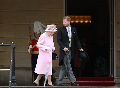 Queen Elizabeth II, wearing pink, and Prince Harry, wearing a morning coat walking together in Londo...
