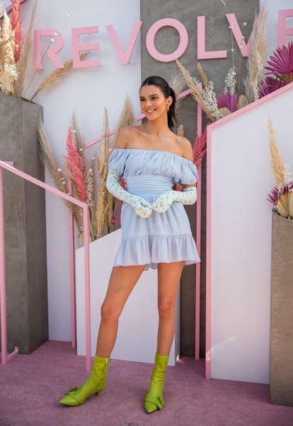 Kendall Jenner is seen wearing a blue off-the-shoulder mini dress, moon-printed gloves, and lime gre...