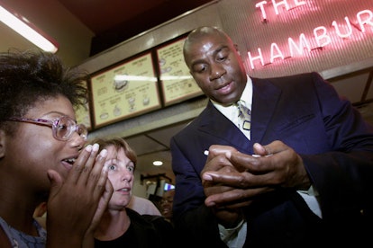 Magic Johnson signs autographs at the public announcement that an investment group he leads will acq...