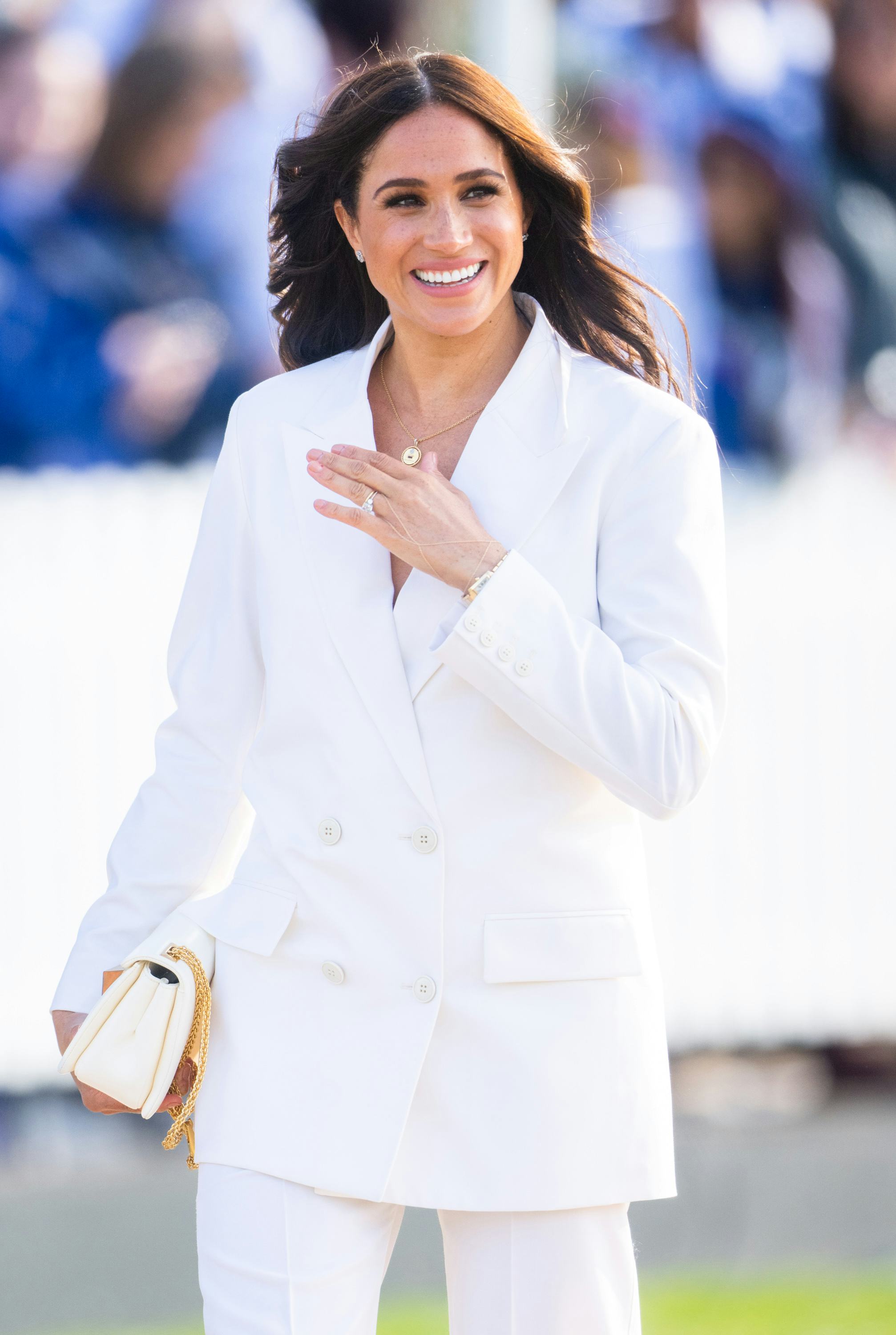Meghan, Duchess of Sussex wore an all-white suit to a reception for friends and family of competitor...