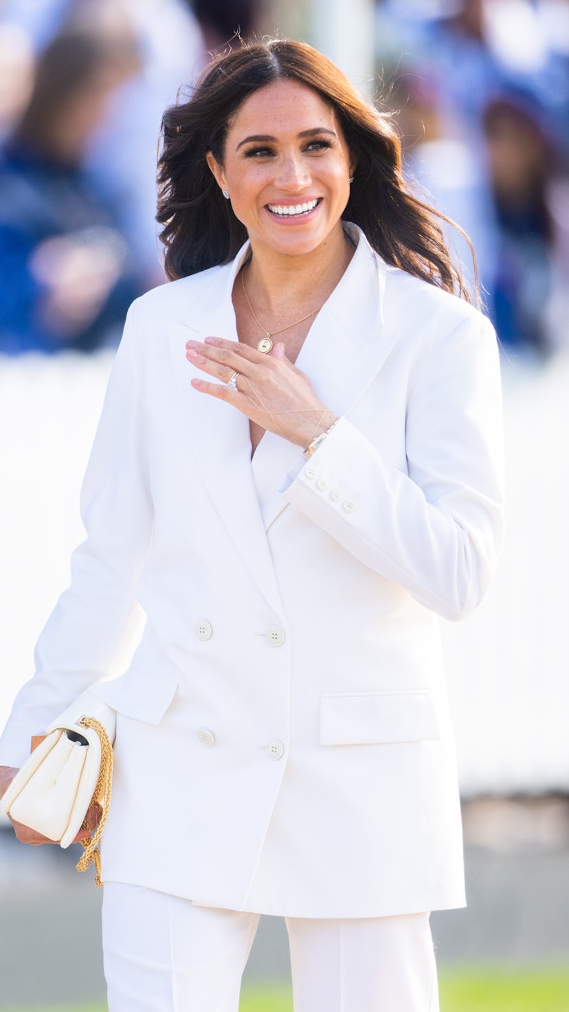 Meghan, Duchess of Sussex wore an all-white suit to a reception for friends and family of competitor...