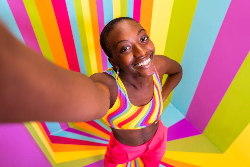 Beautiful african american young woman dancer having fun inside a rainbow box room - Cool and stylis...