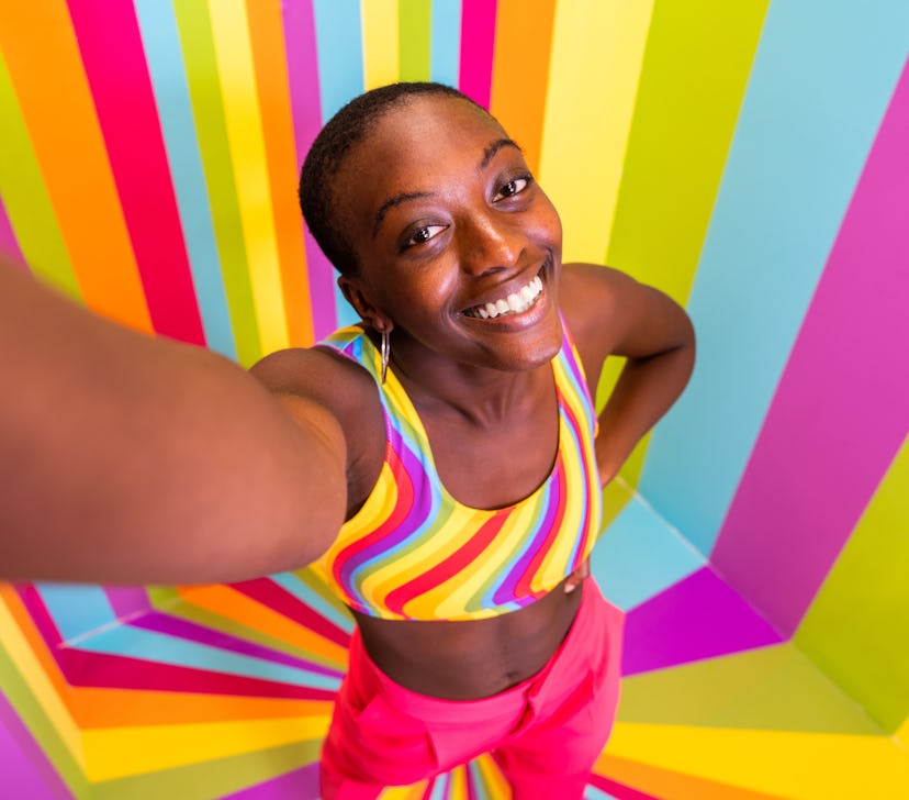 Beautiful african american young woman dancer having fun inside a rainbow box room - Cool and stylis...