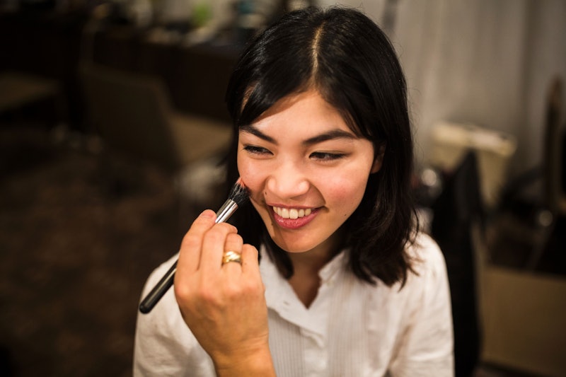 In this picture taken on Ocotber 17, 2016, a stylist works on the make-up for Japanese model Rina Fu...