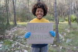 A black boy holds up a "Happy Earth Day" sign