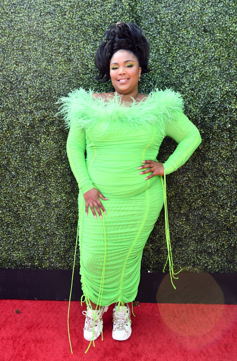Lizzo at the MTV Movie and TV Awards in a green dress and embellished sneakers