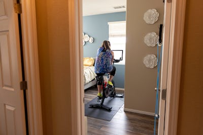 High quality stock photos of a mid-adult woman riding a home exercise bike taking a professional les...