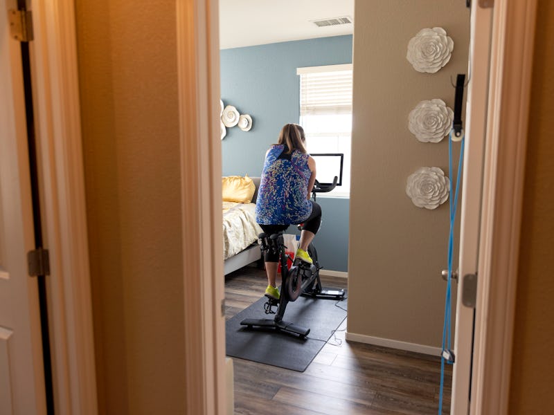 High quality stock photos of a mid-adult woman riding a home exercise bike taking a professional les...