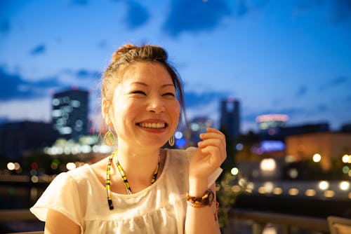 A woman smiles with happy tears. These are the four most highly sensitive zodiac signs, according to...