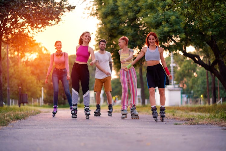Group of friends rollerblading and talking about cardio workouts.