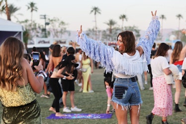A woman at the Coachella festival thinks of Coachella quotes and slogans for her Instagram post.