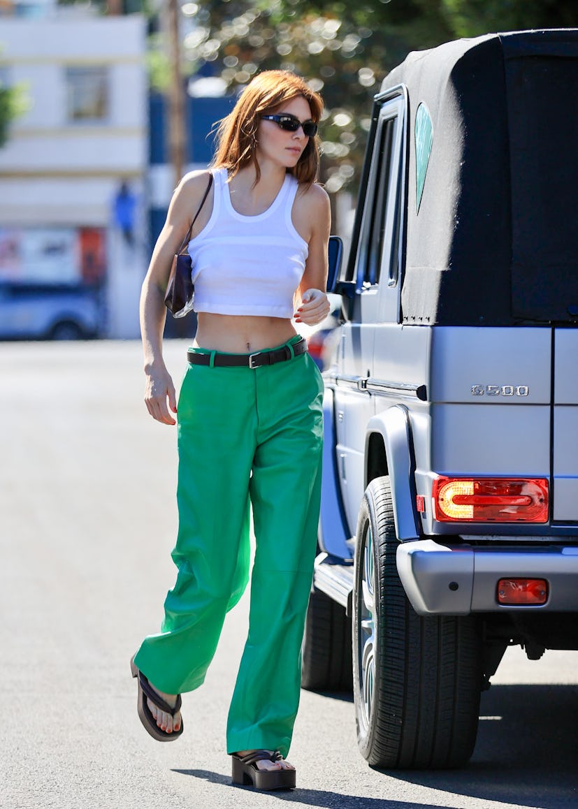 Kendall Jenner wearing green pants and a ribbed tank with platform flip flops